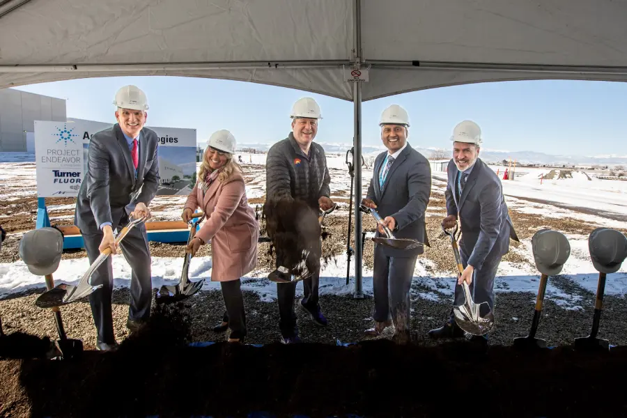 Mayor Tracie Crites, Governor Jared Polis, and Agilent executives wearing hard hats and using shovels to break ground on Agilent's new manufacturing facility in Frederick, Colorado.
